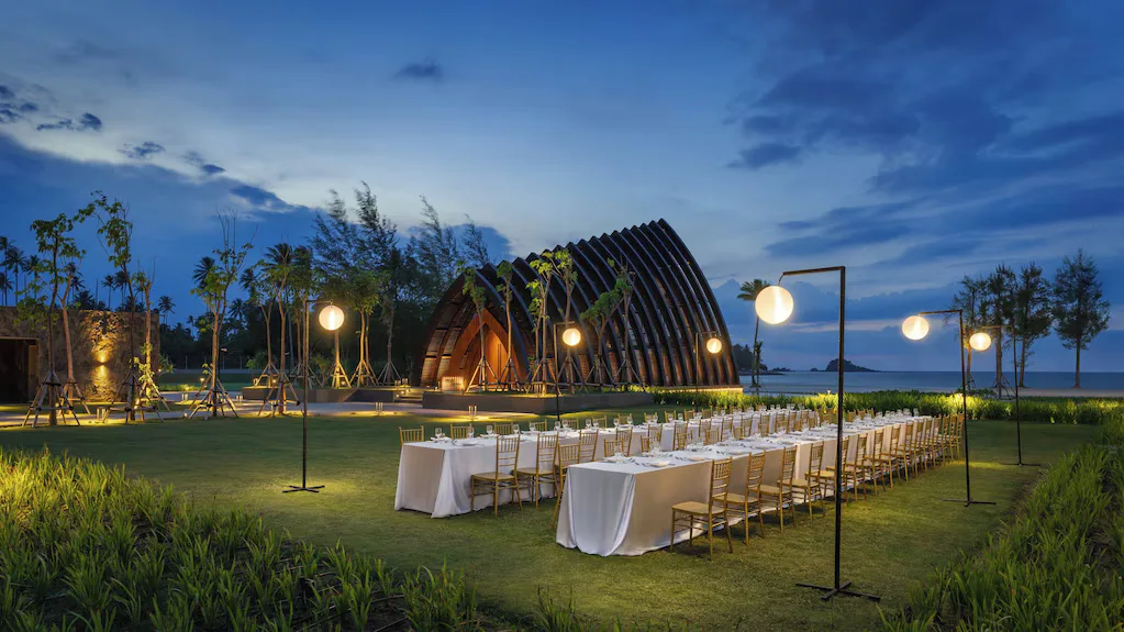 Outdoor dining setup by the sea at dusk